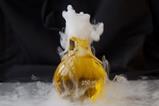 A conical flask of yellow liquid bubbles with a heavy white smoke