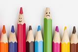 Colouring pencils. One is sharpened and has a smiley face and another has a broken tip and a sad face