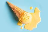 A vanilla ice cream in a waffle cone that has fallen on the floor and melted