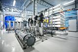 Inside a reverse osmosis plant with a collection of pipes and machinery.