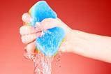 A hand squeezing water from a sponge