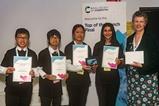 Four students holding certificates with Gill Reid