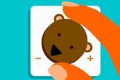A close up of someone turning down a dial of a bear's face