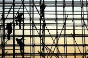 Workers climbing scaffolding in silhouette