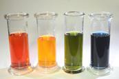 Four glass containers with bromothymol blue indicator solution displaying different colours, including red, yellow, green and blue
