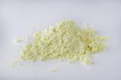 A small heap of purified yellow sulfur powder against a neutral background