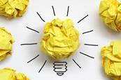 Screwed up piece of yellow paper with lines to make it look like a lit lightbulb