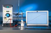 Chemistry equipment with a data logger, thermometer and a laptop recording an increasing temperature on a graph