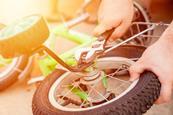 An adult using a spanner to remove training wheels from a child's bike