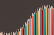 A photographic illustration of a series of pencils arranged side-by-side with points following the shape of an upward curve, as if on a graph