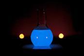 A round glass flask glowing blue