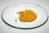 A sample of solid yellow lead iodide on a glass dish against a white background