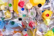 A full-frame photograph of a heap of plastic bottles and containers for recycling