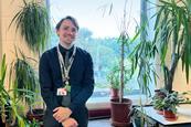 A teacher with some plants in his science classroom