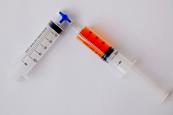 Two syringes connected via a valve. One is empty and the other has 40 millilitres of an orange gas