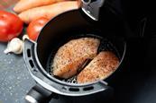 Chicken breasts cooking in an air fryer