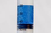 A test tube of boiling water at room temperature, with blue food dye for clarity