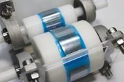 Two rollers with sticky tape on spread out a silvery substance in to a fine layer