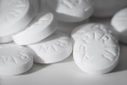 Macro photograph of white tablets marked with the word aspirin