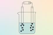 A diagram of a beaker of liquid with a battery hooked up via electrodes which are attracting charged particles from the liquid