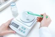 An image of a person weighing out a reagent on a balance scale