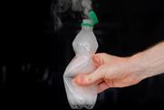 A hand squeezing a plastic bottle with vapour emerging from the neck