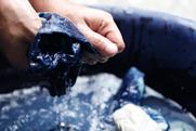 Water, and fabric, dyed indigo. With hands wringing out water