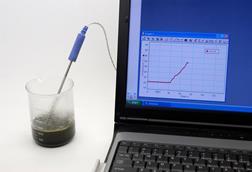 A beaker of dark green bubbling liquid with condensation forming on the side had a temperature probe reporting into a laptop which shows a line graph of the temperature increasing