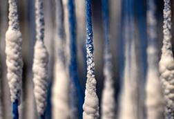 Blue strings hanging down with a white salt crystallizing on them