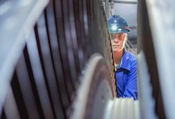A female engineer inspects a turbine in a nuclear power plant