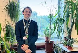 A teacher with some plants in his science classroom