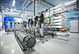 Inside a reverse osmosis plant with a collection of pipes and machinery.