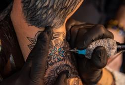 A tattoo artist using blue ink