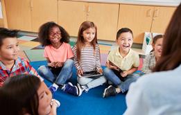 Group of primary pupils siting on the floor