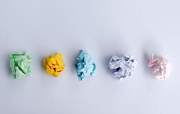 Five different coloured pieces of paper crumpled into balls