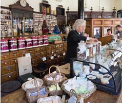 A woman serving behind the counter at the Victorian pharmacy