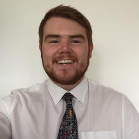 An image showing a headshot of Harry Lord wearing a periodic table tie