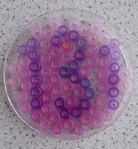 A Petri dish filled with colour changing beads to spell out the number 13