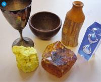 Figure 5 - Miscellaneous objects: a silver goblet, a wooden bowl, manuka wooden vase, Perspex hour glasss, kauri gum and a lump of natural sulfur
