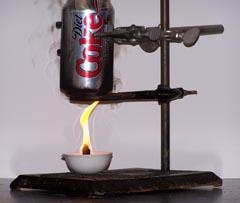 Enthalpy of combustion experiment - An aluminium can is held in place above a small open flame