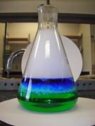 The results of the experiment with layers of green, light blue, dark blue and mist in a flask