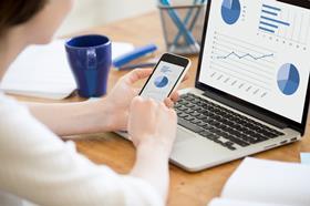 Image of a woman working with smartphone and laptop