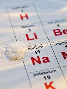 Pinch of salt next to the chemical symbol for sodium on the periodic table; whole table not shown