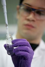 An apprentice holding a glass tube