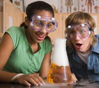 Students watching a bubbling flask with amazement