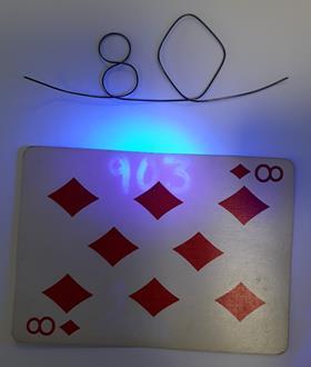 A wiregram made of nitinol and playing card with a code written in UV – clues to a chemistry puzzle