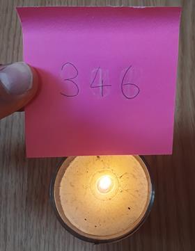 Revealing a code written in erasable ink using the heat of a candle