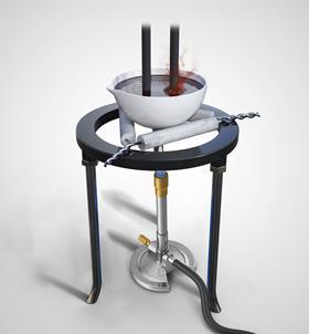 A bunsen burner under a tripod that had a ceramic dish with electrodes in and a dark liquid that is emitting a dark smoke