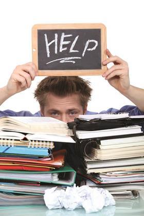 Holding up a 'help' sign above a stack of revision files