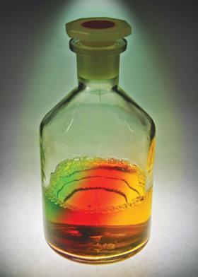 A reagent bottle with a three-colour liquid